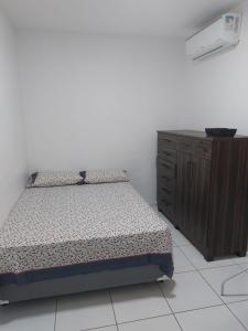 a bedroom with a bed and a wooden cabinet at Andrea in Petrolina
