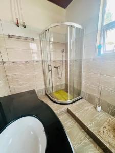 Un baño con ducha, inodoro y lavabo. en KIGALi LODGE APART, en Kigali 17 fotos más