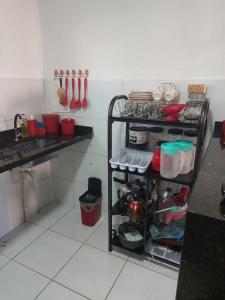 a kitchen with a shelf with dishes and utensils at Andrea in Petrolina