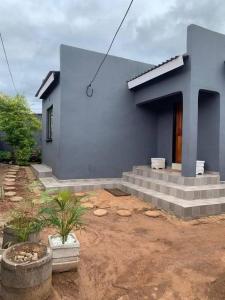 a blue house with steps in front of it at Encome Guest house in Pongola