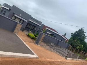 a house with a fence in front of it at Encome Guest house in Pongola +1 photo