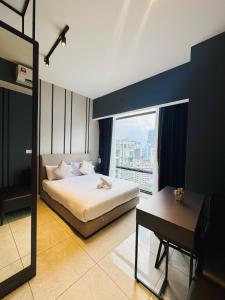 una camera da letto con un letto, una scrivania e una finestra di Axon Purple Suites Pavilion Bukit Bintang a Kuala Lumpur