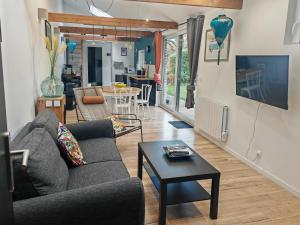 a living room with a couch and a table at La Jeannette Sainghin-en-Mélantois in Sainghin-en-Mélantois