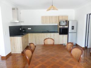 a kitchen with a table and chairs and a refrigerator at Chez Pépète in Magescq