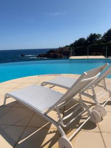 una poltrona bianca seduta accanto alla piscina di Studio calme vue mer pieds dans l'eau a Saint-Raphaël