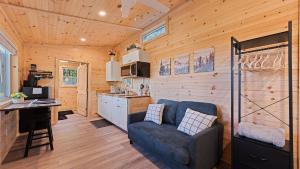 a kitchen and living room with a blue couch in a cabin at Mountain Haven: Cozy Tiny Home on 16 Acres in Jonathan +19 photos
