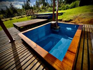 a pool on a deck with a table and a bench at Cabin in Puerto Godoy - Maullin in Maullín