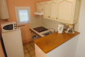 a kitchen with a white refrigerator and a microwave at Gites Bulanettes 'Bergerie' Sainte Marie de Campan in Campan +8 photos