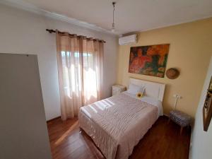a bedroom with a white bed and a window at Casa Azélia e Albino in Aves