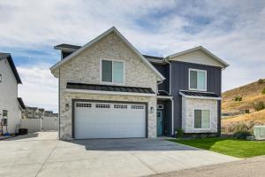 a house with a garage door in a driveway at Modern and Spacious Garden City Home with Pool Access! in Garden City