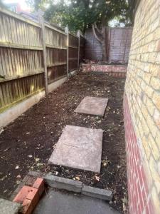 a backyard with a fence and some stepping stones at Harrow and Wealdstone studio in Harrow