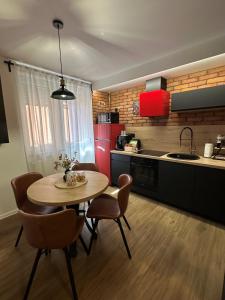 a kitchen with a table and chairs in a room at Apartman KOCKICA Entry with PIN 0-24h , Free parking in Slavonski Brod