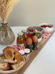 ein Tablett mit Eiern, Brot und anderen Lebensmitteln in der Unterkunft Suite Brume - Maison les Arcades au pied de la gare de Charleville-Mézières in Charleville-Mézières