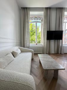 ein Wohnzimmer mit einer Couch und einem Couchtisch in der Unterkunft Suite Brume - Maison les Arcades au pied de la gare de Charleville-Mézières in Charleville-Mézières