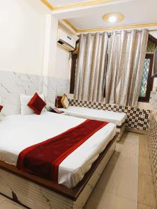 une chambre avec un grand lit avec une fenêtre dans l'établissement SURYA INN -- 05 Minutes Walk Nizamuddin Railway Station, à New Delhi