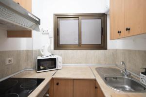 大加那利岛拉斯帕尔马斯BKD1 A tan solo 50 metros de la playa Las Canteras的带水槽和微波炉的小厨房