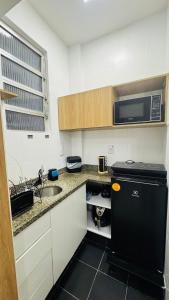 a small kitchen with a sink and a microwave at Studio 714 - Flamengo in Rio de Janeiro