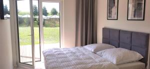 a bedroom with a bed and a glass door at Ferienhaus-Elbblick-Haselau in Haselau