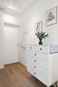 a white dresser with a vase on top of it at Central and modern in Tromsø