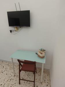 a white table with a tv and a chair at MARGIE'S HOUSE SEA VIEW - Apartment in Procida