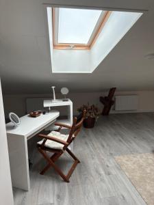 a desk and a chair in a room with a skylight at Dream Apartment in Liepāja +6 photos
