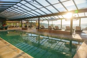 a swimming pool with chairs and a view of the mountains at Chris Wellness Resort Hotel in Campos do Jordão