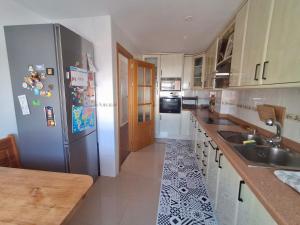 Una cocina con frigorífico de acero inoxidable y fregadero. en Central and Cozy Retreat - Ferienwohnung Almería, en Almería