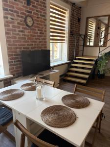 a room with a table with chairs and a brick wall at Dream Apartment in Liepāja