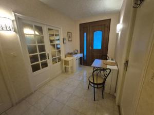 a room with a table and a desk and a door at Chambre bleu dans un appartement independant de l habitation in Nouzilly