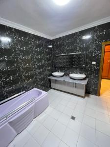 a bathroom with two sinks and a bath tub at Kidy Guest House in Addis Ababa