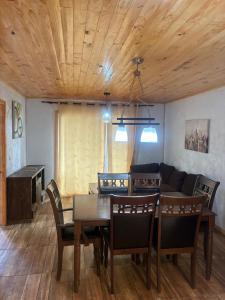 a dining room with a table and a couch at Condominio Bucalemu in Bucalemu