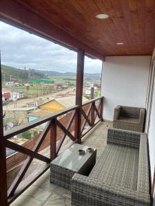 a balcony with two chairs and a table and a view at Condominio Bucalemu in Bucalemu