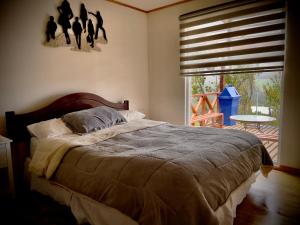 a bedroom with a bed and a window with a table at Cabin in Puerto Godoy - Maullin in Maullín +7 photos