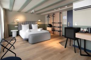 a bedroom with a white bed and a desk at Hotel Zeedijk City Centre in Amsterdam
