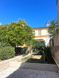 トゥーロンにあるRosa Bonheur house parking Gardenの木々と建物の空き道