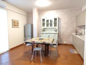 une cuisine avec une table, des chaises et un réfrigérateur dans l'établissement La casa di Giada, appartamento a piano terra in villetta con aria condizionata, wi-fi e parcheggio gratuito, à Poggi