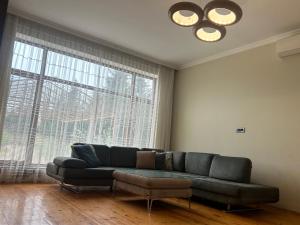 a living room with a couch and a large window at Kingasimov in Baku +1 photo