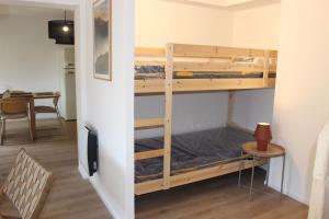 a room with two bunk beds and a table at Grand duplex ensoleillé pour 7 Résidence Violaine in Le Monêtier-les-Bains