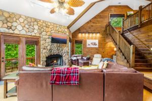 ein Wohnzimmer mit einem Sofa und einem Steinkamin in der Unterkunft Cabin Zen, Riverfront, Hot Tub, Arcades, Sleeps 8 in Ellijay + 48 Fotos