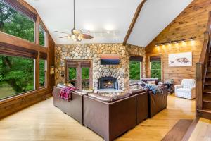 ein Wohnzimmer mit Couch und Kamin in der Unterkunft Cabin Zen, Riverfront, Hot Tub, Arcades, Sleeps 8 in Ellijay