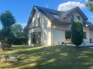 罗兹Willa Zamorska z bezpłatnym dostępem do basenu w Spa的一栋带有大院子的白色大房子