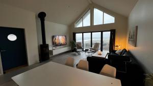a living room with a table and a large window at Stylish Coastal House with Stunning Ocean View in Borhaug