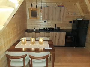 a kitchen with a wooden table with chairs and a kitchen with a refrigerator at Grahovo Čelin Stream in Grahovo