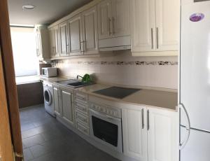 a white kitchen with white cabinets and a refrigerator at Monver 10 in Benidorm