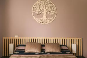 a bedroom with a bed with a tree on the wall at Gites Bulanettes 'Bergerie' Sainte Marie de Campan in Campan