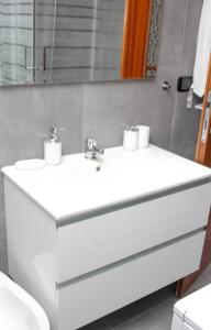 a bathroom with a white sink and a mirror at Infinity House Ivrea in Ivrea