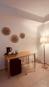 Una mesa con una cafetera y una lámpara en una habitación. en Casa Morgana camera Irene, en Scilla