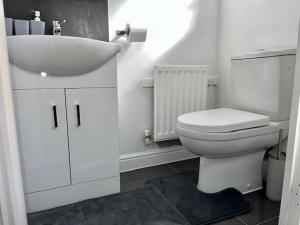 a white bathroom with a sink and a toilet at Home In Maidstone in Maidstone
