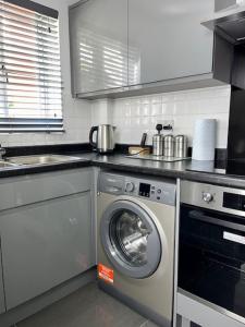 a kitchen with a washing machine and a sink at Home In Maidstone in Maidstone