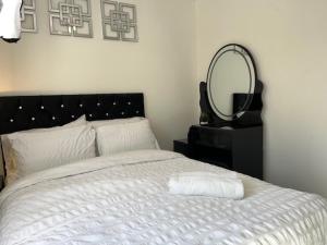 a bedroom with a bed with a mirror on the wall at Home In Maidstone in Maidstone +10 photos